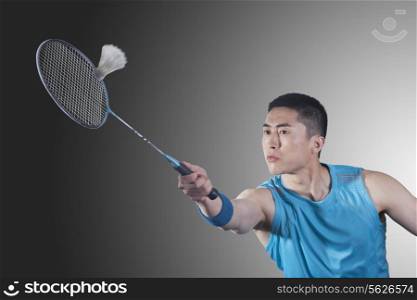 Young man playing badminton, hitting