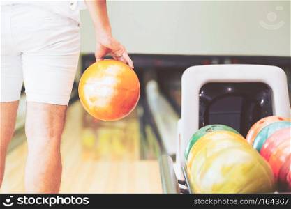 Young man playing bowling at the sport club.. Young man playing bowling.