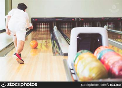 Young man playing bowling at the sport club.. Young man playing bowling.