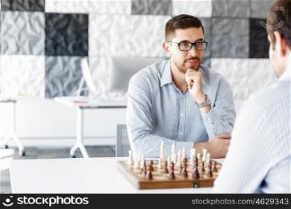 Young man playing chess . Young businessman playing chess in office