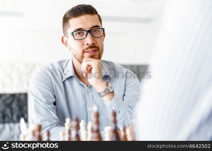 Young man playing chess . Young businessman playing chess in office