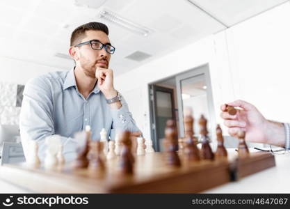 Young man playing chess . Young businessman playing chess in office