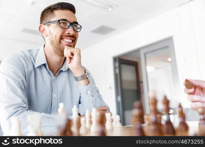 Young man playing chess . Young businessman playing chess in office