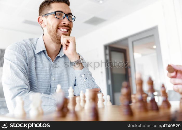 Young man playing chess . Young businessman playing chess in office