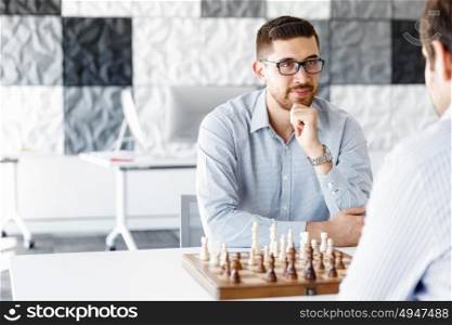 Young man playing chess . Young businessman playing chess in office