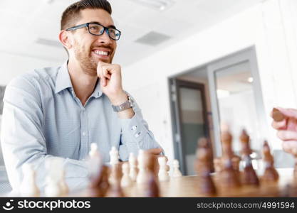 Young man playing chess . Young businessman playing chess in office