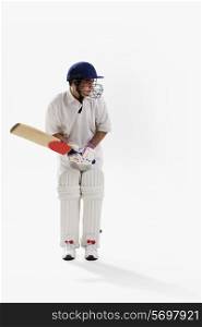 Young man playing cricket isolated over white background
