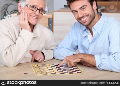 Young man playing game with elderly woman