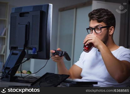 Young man playing games long hours late in the office