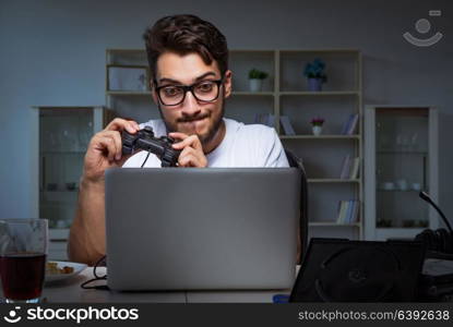 Young man playing games long hours late in the office