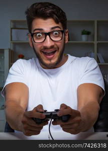 Young man playing games long hours late in the office