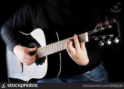 Young man playing on black guitar.