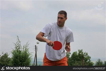 Young man playing table tennis in nature