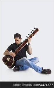 Young man playing the sitar