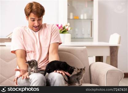 Young man playing with kitten at home
