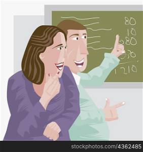 Young man pointing at a blackboard and looking at a young woman