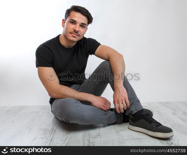 young man posing. a young man with black tshirt agaist white background