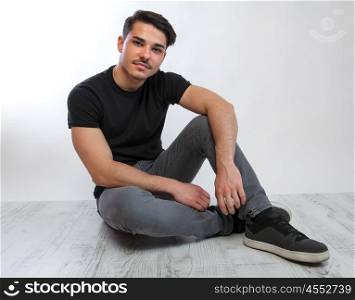 young man posing. a young man with black tshirt agaist white background