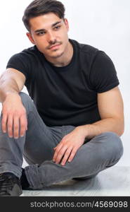 young man posing. a young man with black tshirt agaist white background