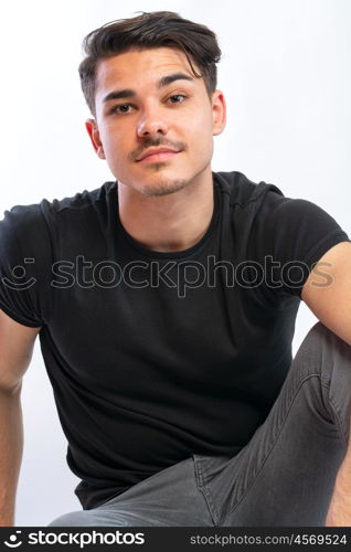 young man posing. a young man with black tshirt agaist white background