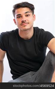 young man posing. a young man with black tshirt agaist white background