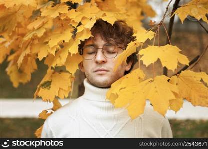 young man posing autumn leaves 2