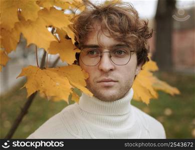 young man posing autumn leaves 3