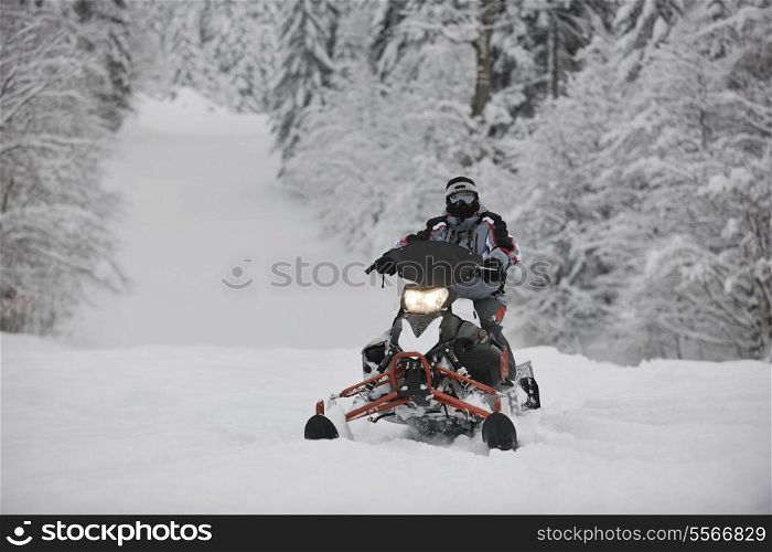 young man posing on snowmobile at beautiful winter day