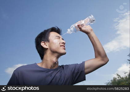 Young Man Pouring Bottled Water Over His Head