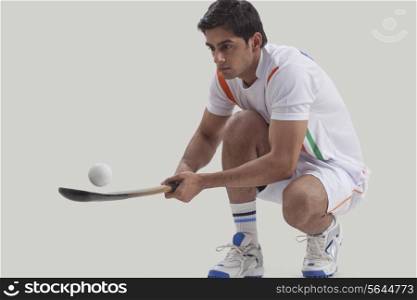 Young man practicing hockey isolated over gray background