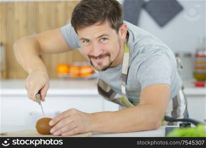 young man preparing a tomato salad