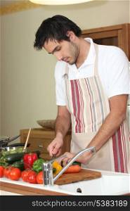 Young man preparing vegetables