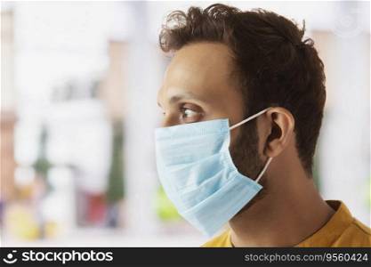 Young man pretecting himself by wearing a mask while going outdoors
