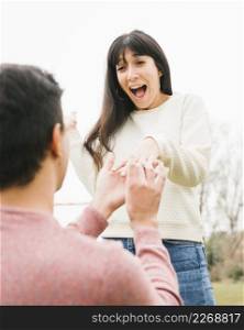 young man proposing excited girlfriend