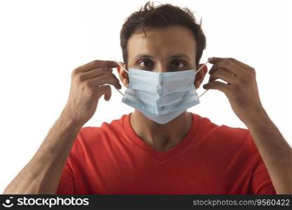 Young man protecting himself from various infections by wearing a mask