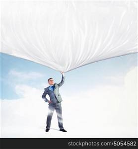 Young man pulling banner. Image of young businessman pulling blank banner from above