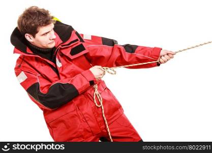 Young man pulling rope. . Young man pulling rope. Male in waterproof coat. Adventure danger concept.