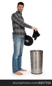 Young man putting dirty socks in a laundry basket, isolated on white