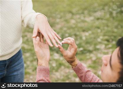 young man putting wedding ring sweetheart finger