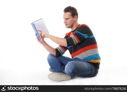 young man reading a book or studying on the floor isolated on white