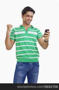 Young man reading an sms and rejoicing