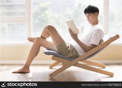 Young man reading at home