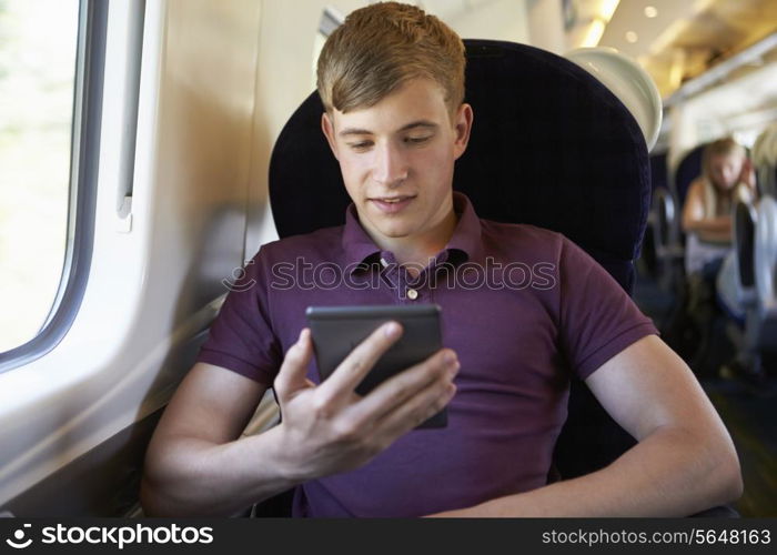 Young Man Reading E Book On Train Journey