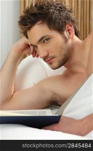 Young man reading in bed