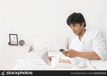 Young man reading sms on mobile phone