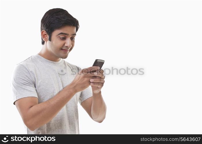 Young man reading text message and smiling