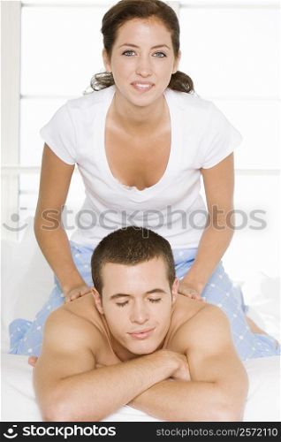 Young man receiving back massage from a young woman