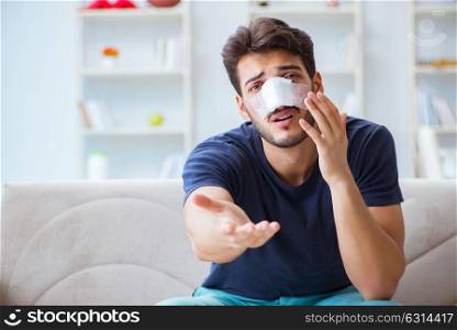 Young man recovering healing at home after plastic surgery nose . Young man recovering healing at home after plastic surgery nose job