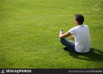 Young man relaxed sitting on the grass