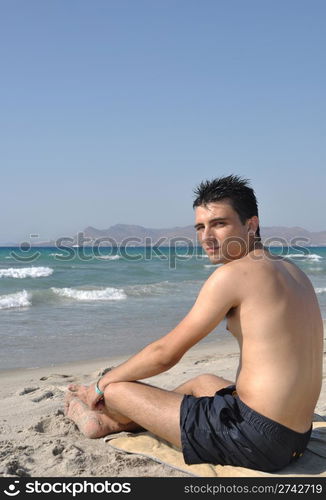 young man relaxing at Kos beach in Greece (blue sky)